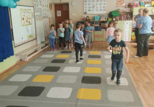 Dzieci ścigają się z jajkami na łyżeczkach.