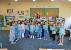 Niebieska drużyna (dzieci w niebiskich strojach, trzymające niebieskie baloniki) gotowa do igrzysk.
