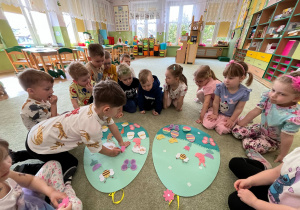 Dzieci przyczepiają na pisanki (wykonane z filcu) różne ozdoby wielkanocne.