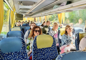 Rodzice z dziećmi siedzą w autokarze.