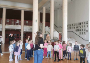 Grupa dzieci zwiedza teatralne foyer.