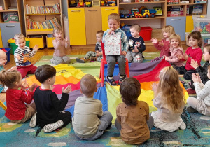 Dzieci siedzą w kręgu, w środku kręgu na krzesełku siedzi jubilat.