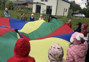 Grupa dzieci podczas zabawy z chustą animacyjną.