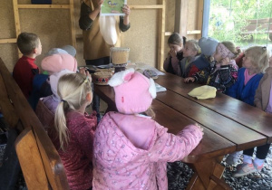 Dzieci słuchają ciekawostek o ptakach, prowadząca zajęcia prezentuje zdjęcie ptaka.
